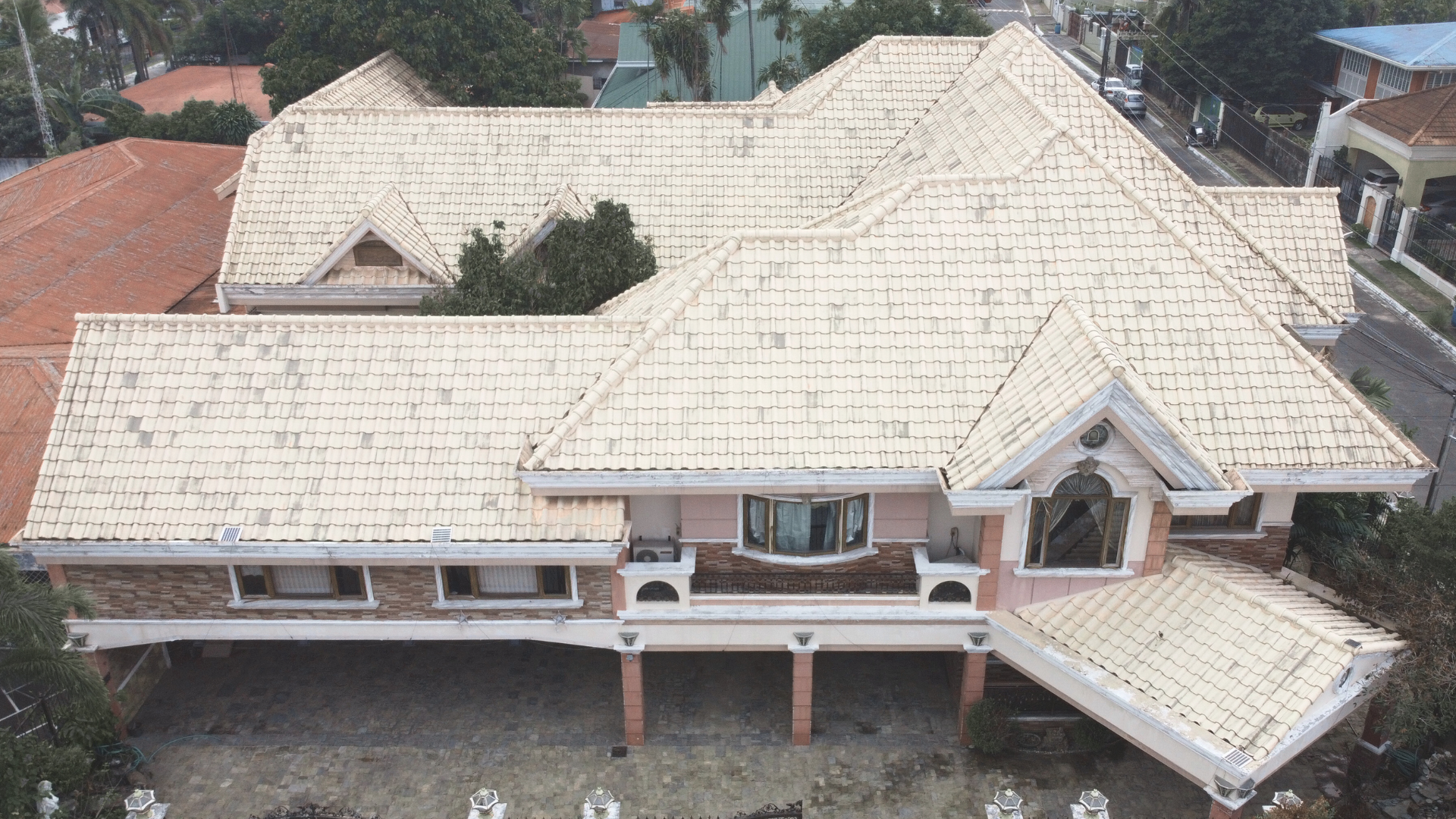 Aerial drone view of the large residential home featuring fully cleaned and restored terracotta roof tiles following professional softwashing.