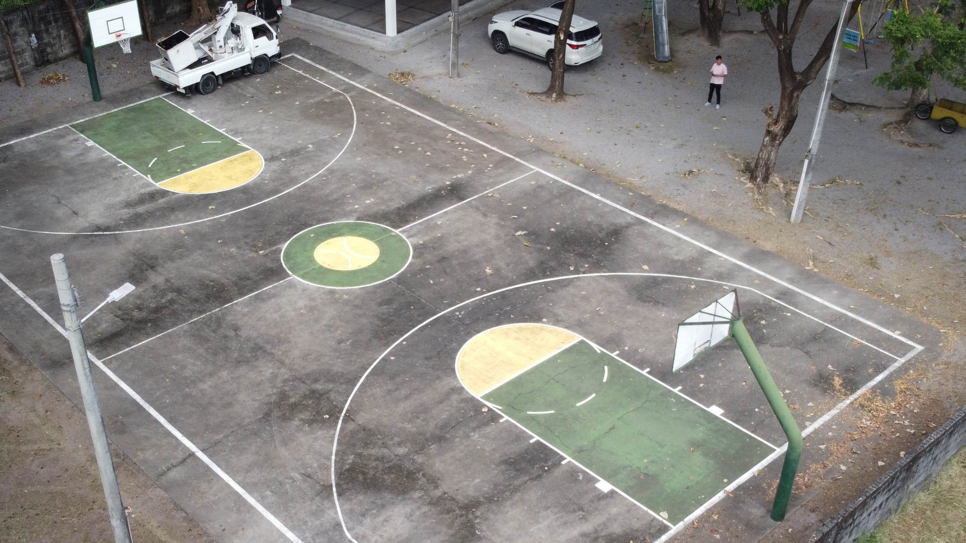 Dirty outdoor concrete basketball court covered in grime before professional pressure washing.