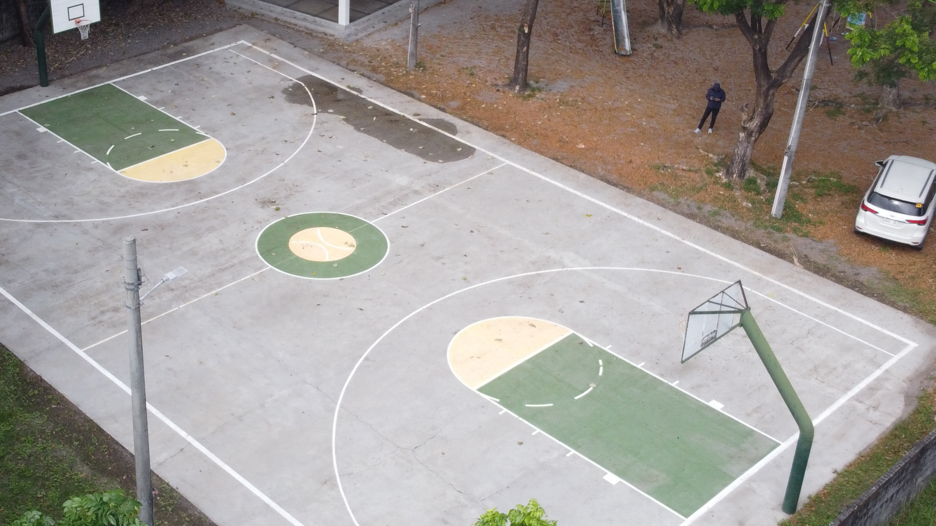 Clean outdoor concrete basketball court with bright restored paint after professional pressure washing.