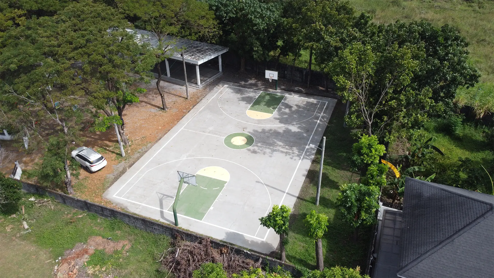 Overhead view of a freshly cleaned outdoor basketball court with a bright, slip-free concrete surface.