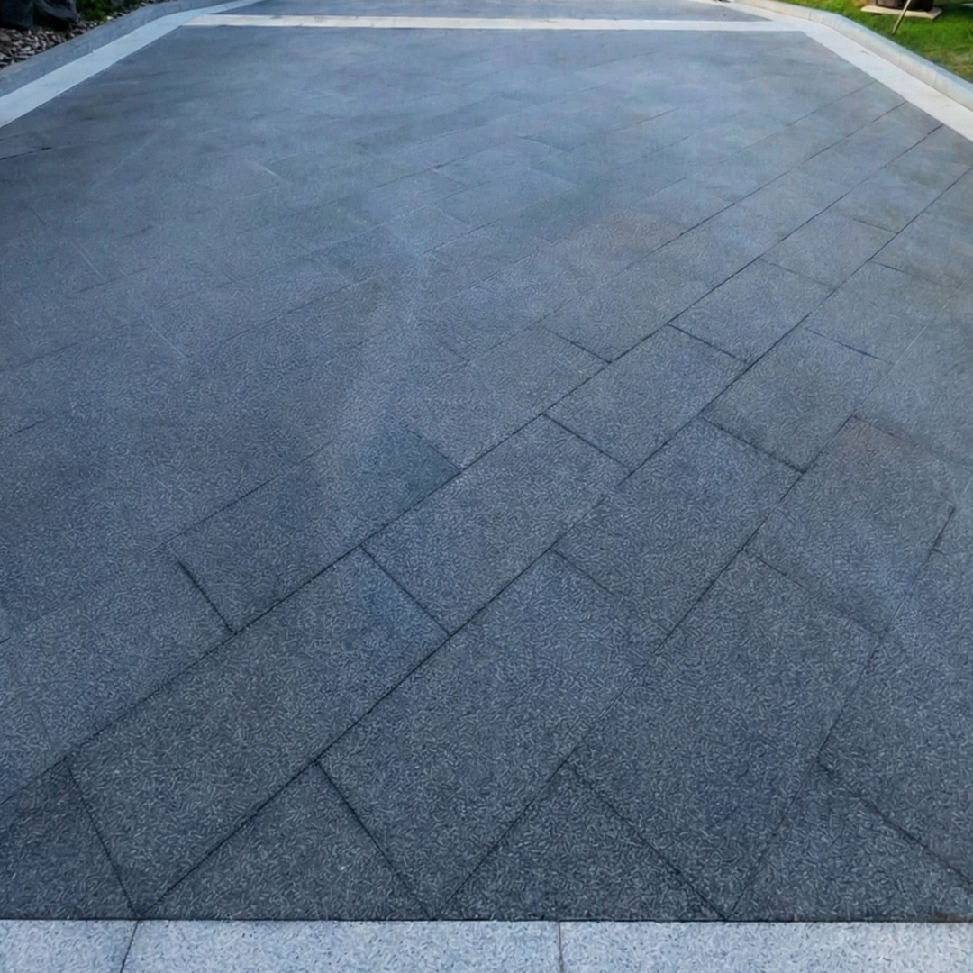 High-angle shot of clean, gray outdoor floor tiles with sharp grout lines after a deep pressure washing treatment.
