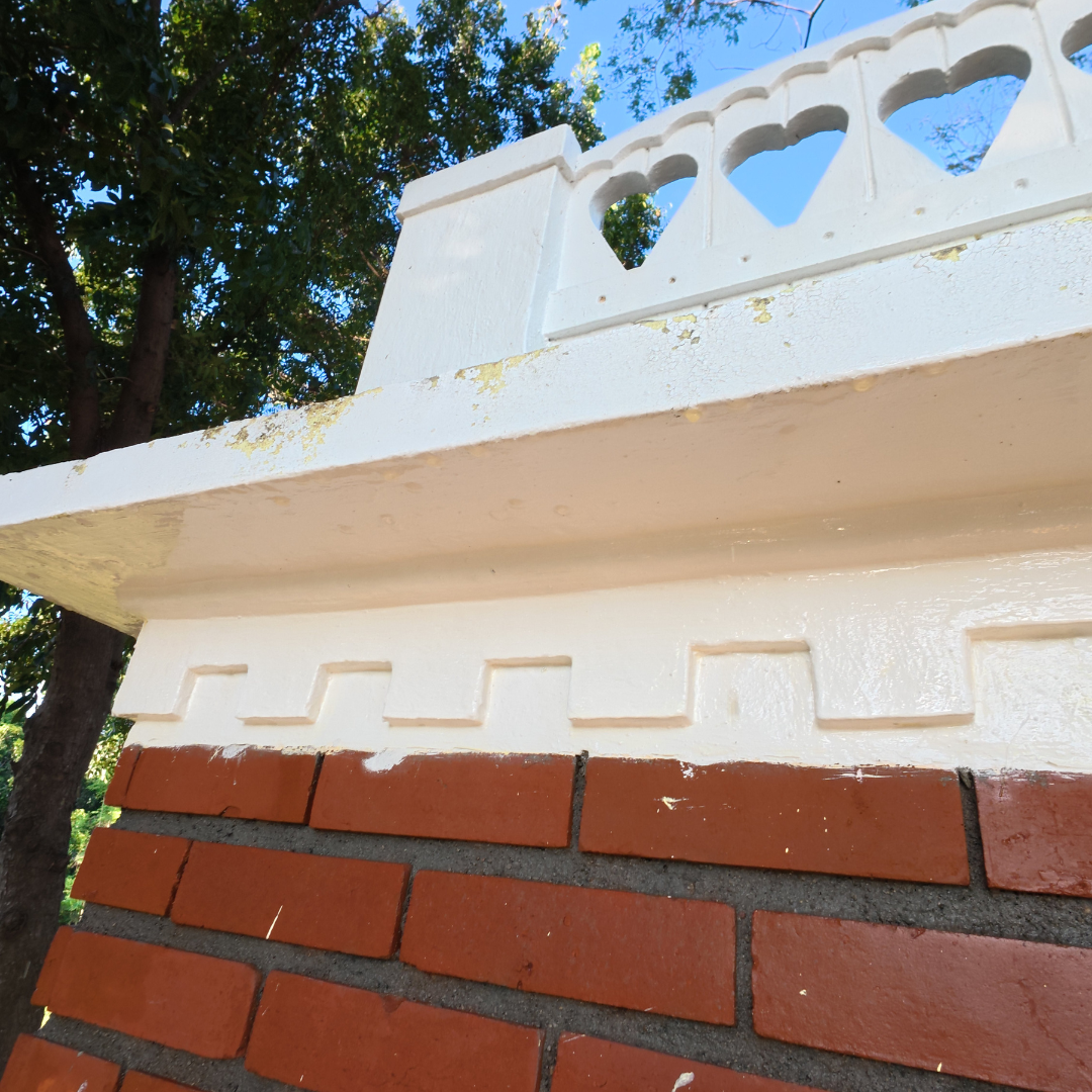 Detail of clean white masonry and red brick facade on a residential structure after eco-friendly softwashing.