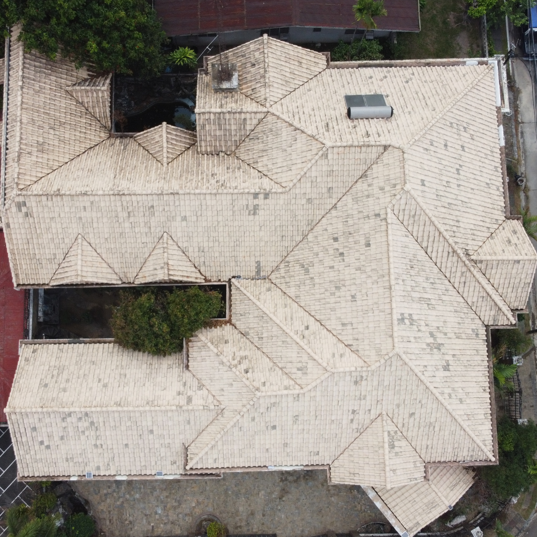 Aerial view of a clean multi-gabled tile roof after a professional softwash treatment by Tingkad Softwash.