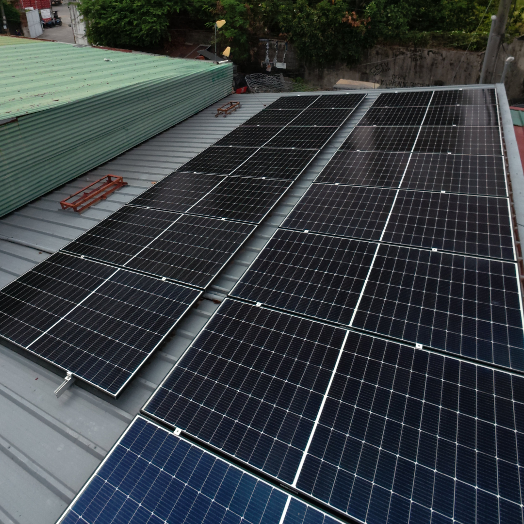 High-angle drone shot of a fully cleaned solar power system on a commercial building roof.